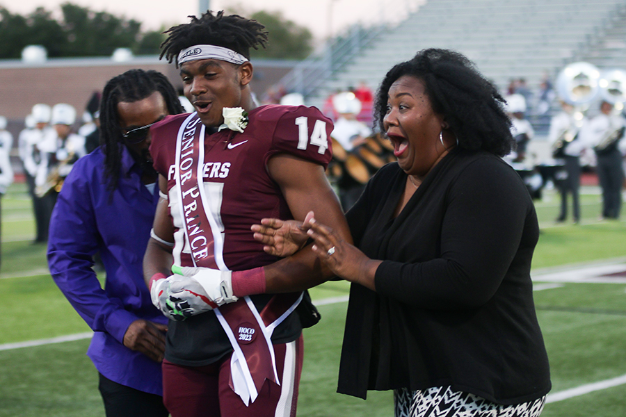 Senior homecoming king Kaiden Reese reacts to the news of his win with his parents before the homecoming game on Friday, Oct. 13.