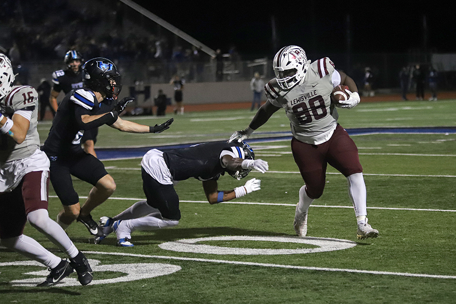 Tight end Xavier Flemming runs the ball past Hebron defense players during the fourth quarter of the last football game of the regular season. 