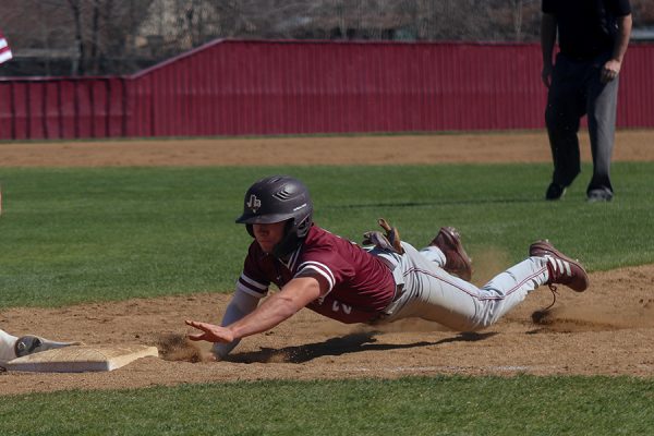 Shortstop Jacob Gallegos dives to touch first base and avoids being out in a game against The Colony on Friday, Feb. 23. The Farmers beat the Cougars 6-5, with Gallegos running in the walk-off hit. 