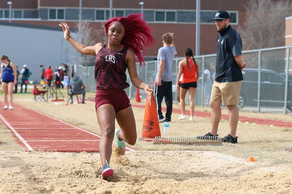 Senior Coretta Williams competes in the long jump competition at the home track meet.