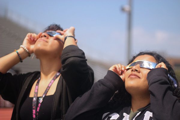 Seniors Melany Perez and Lesli Cuellar spend time together to watch the eclipse.