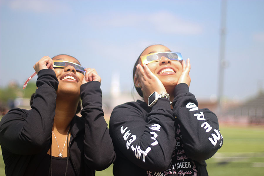 Seniors Alycia Wilson and Amani Virella go to the football field to watch the eclipse together. 
