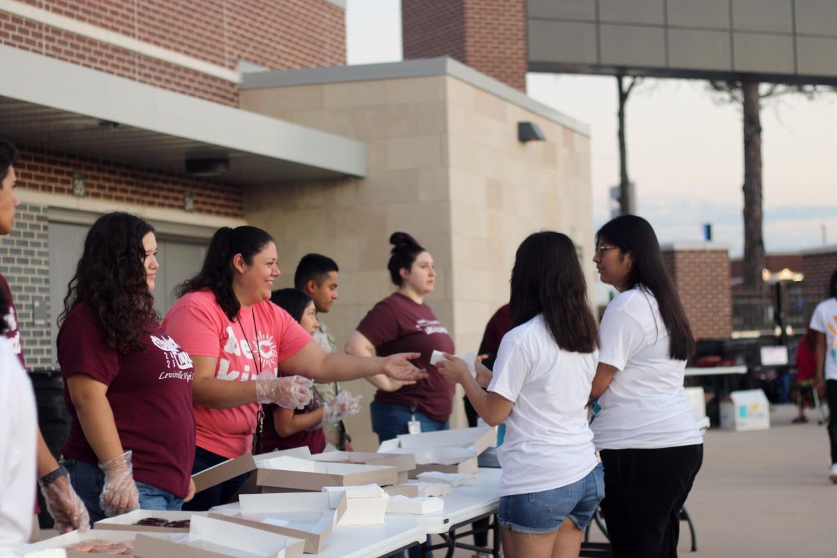 Computer Clerk Luz Faz hands out donuts to Seniors as they watch the sunrise.