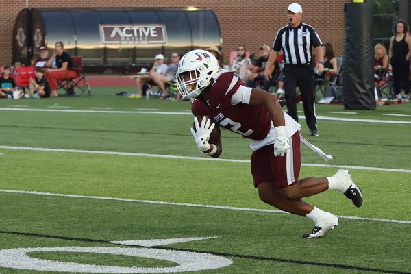 Sophomore Derrick Martin (12) rushes the ball out of the Farmer red zone during the game against Rockwall on Friday, Sept. 13.