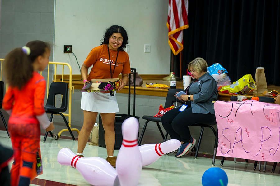 Senior Yvette Gomez and SAPP sponsor Rita Lasuzzo help attendees bowling.