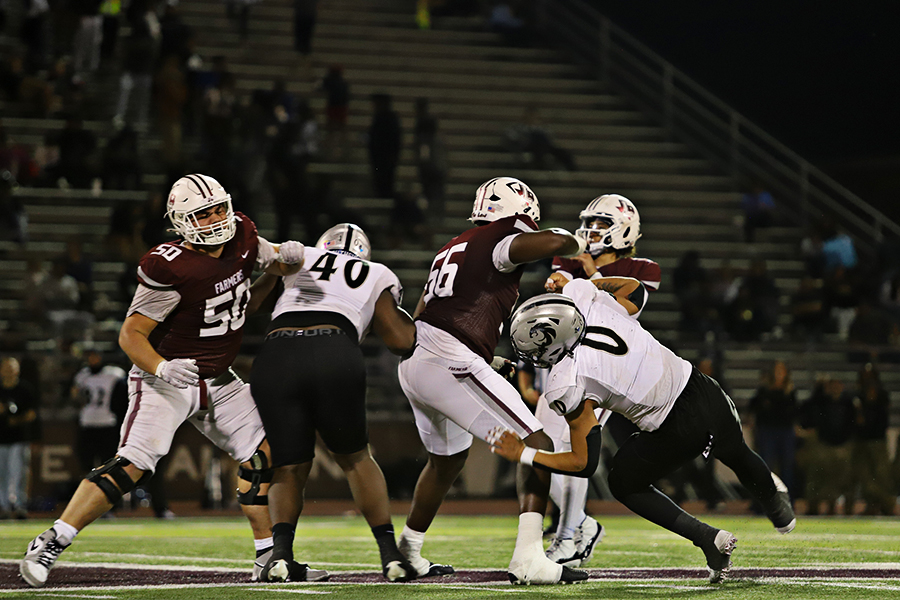 Freshmen offensive lineman Peter Macdonald and senior offensive lineman Michael Fasusi blocking Guyer's defensive lineman for sophomore quarterback Tre Williams.