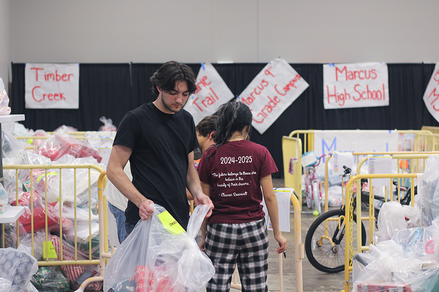 Senior StuCo treasurer Foster McNeil helps place wrapped bags of gifts in their correct spots.