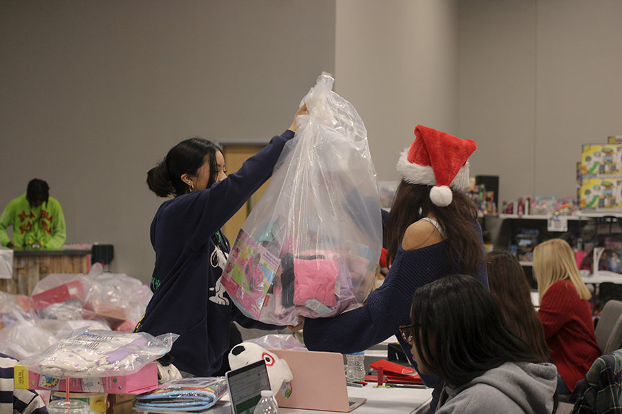 Junior project officer Sophia Wong and junior multicultural officer Yaritza Camilo bag donations. 