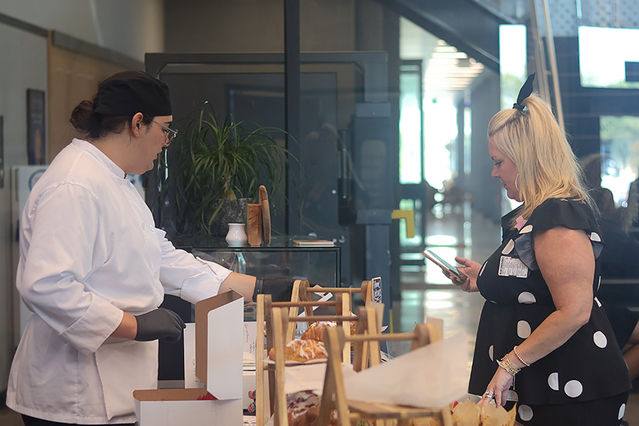 Sous-chef Corbin Harper helps a customer with her purchases.