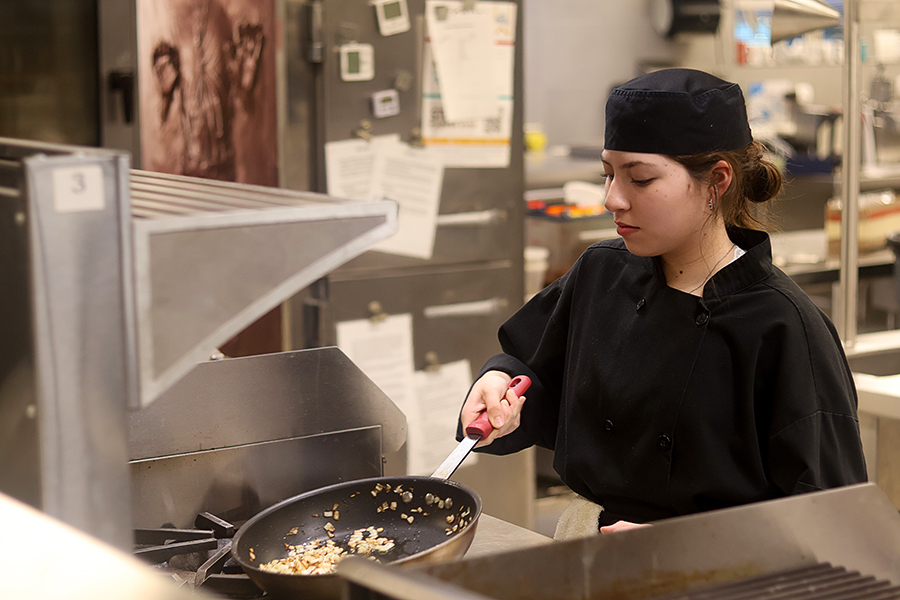 Advanced student Sofía Jiménez caramelizes the onions for the food service. 