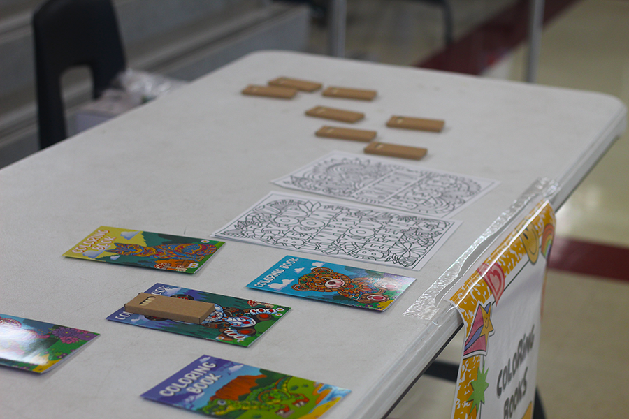 Coloring books and pages are set on the table to encourage students to draw for stress relief