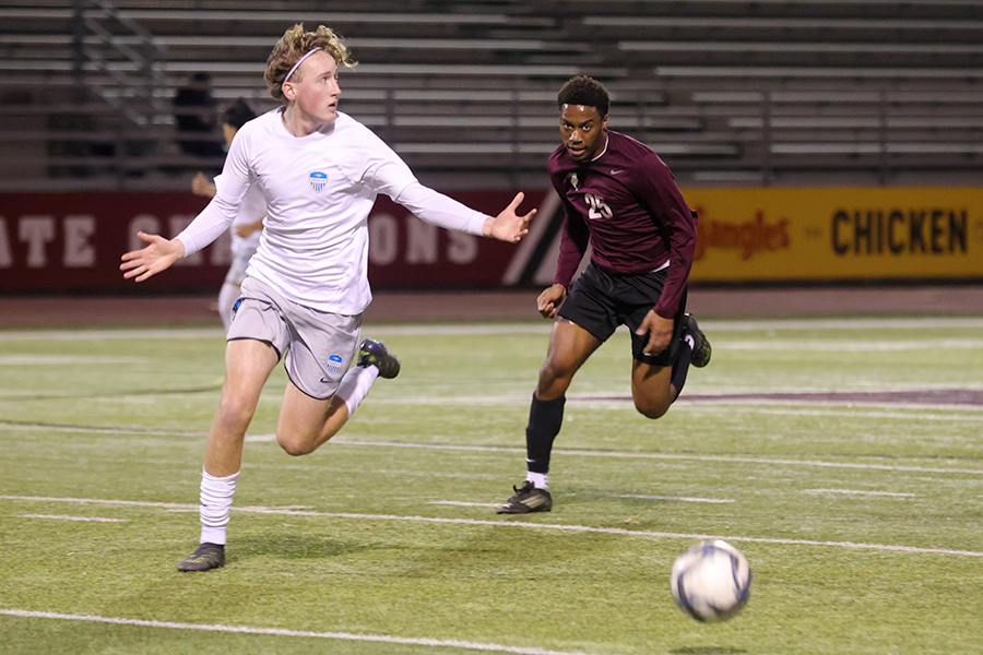 Junior Noah McNeil (25) runs after the ball during the Hebron game.